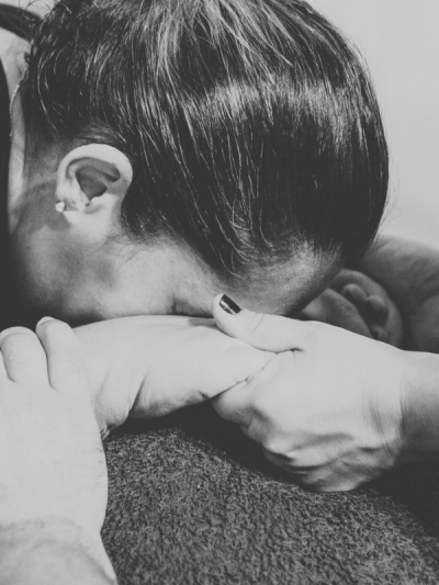 Woman facing down holding a hand