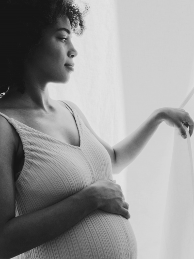 Pregnant woman looking through the window